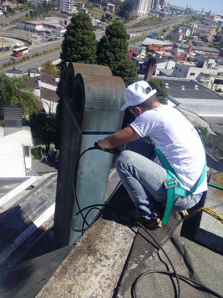 Profissional com cinto de segurança trabalhando em altura no telhado