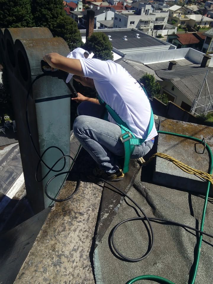 Equipe ancorada trabalhando na cobertura de um prédio
